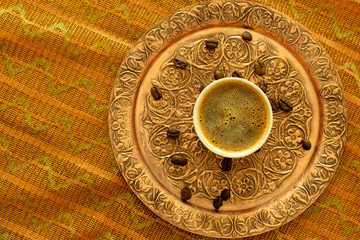 Turkish coffee on copper plate with roasted coffee beans. Top view, copy space.