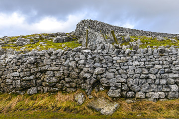 Old wall lined up to rebuilt dry stone walls