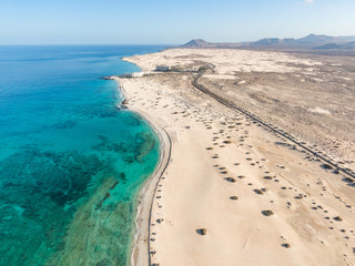 Obraz na płótnie Canvas Panoramic high angle aerial drone view of Corralejo National Park (Parque Natural de Corralejo) with sand dunes located in the northeast corner of the island of Fuerteventura, Canary Islands, Spain.