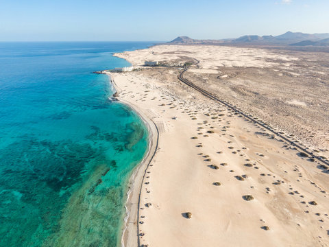 Panoramic high angle aerial drone view of Corralejo National Park (Parque Natural de Corralejo) with sand dunes located in the northeast corner of the island of Fuerteventura, Canary Islands, Spain.