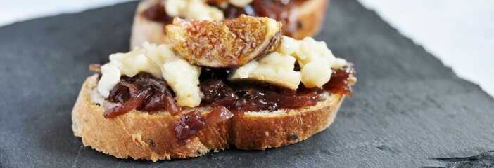 a bruschetta sandwich with onion confiture and cream Camembert cheese on a slice of ciabatta bread