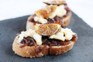 a bruschetta sandwich with onion confiture and cream Camembert cheese on a slice of ciabatta bread