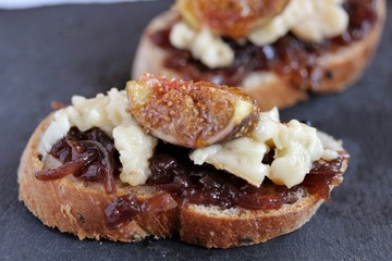 a bruschetta sandwich with onion confiture and cream Camembert cheese on a slice of ciabatta bread