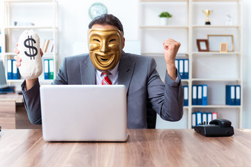 Businessman wearing mask in hypocrisy concept