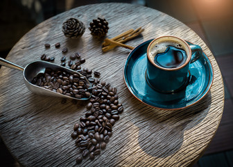 cup of coffee with beans on wooden table