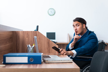 Young male employee in wheel-chair