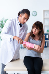 Fototapeta premium Young woman visiting male doctor traumatologist