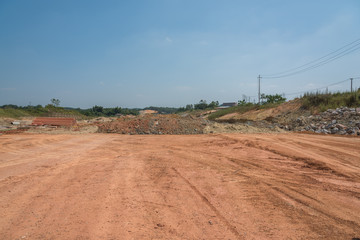 a piece of clay open space and sand piles in an outdoor construction site