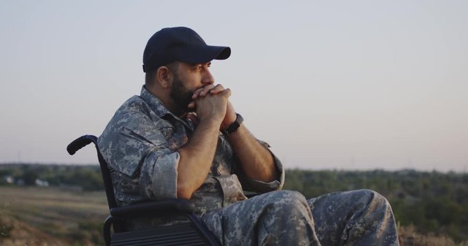 Wheelchaired soldier looking away into distance