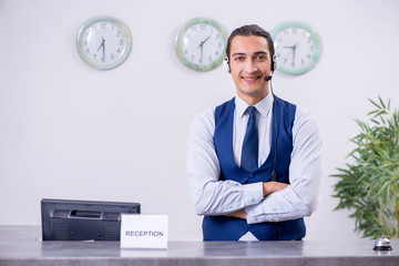 Young man receptionist at the hotel counter