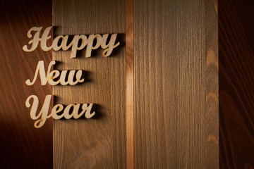 Happy New Year! - A phrase with wooden letters on a wooden backg