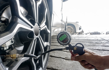 Selective Focus of Hand man holding digital tire pressure gauge to inspection measure quantity...