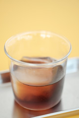 Close up cold brew coffee on metal plate with yellow background