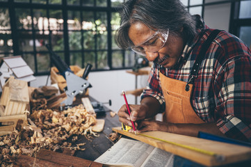 Background image of woodworking workshop: carpenters work table with different tools and wood cutting stand, vintage filter image