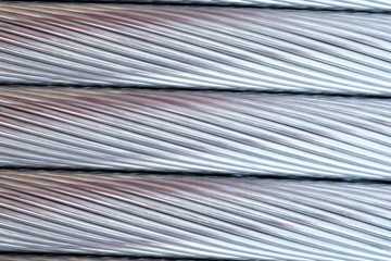 Close up aluminium electricity cable, shiny background. strip texture.