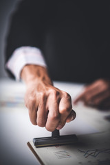 Close-up Of A Person's Hand Stamping With Approved Stamp On Text Approved Document At Desk,  Contract Form Paper