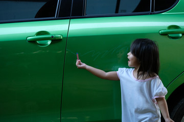 little girl painting and drawing on her own father car