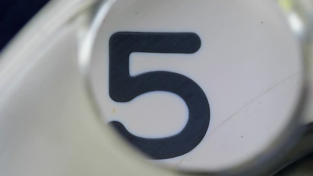 Five. Extreme close-up of a finger dialing an old rotary pay phone. For creation countdown.