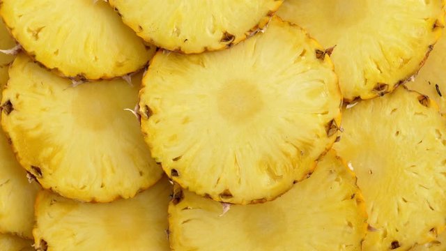 Sliced pieces of delicious pineapple fruit. Tropical food. Rotate