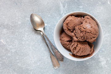 Chocolate ice cream with a bowl on a table. Summer dessert. Selective focus. Copy space. Flat lay.