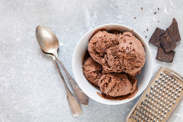 Chocolate ice cream with a bowl on a table. Summer dessert. Selective focus. Copy space. Flat lay.