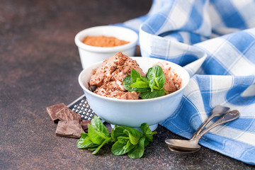 Chocolate ice cream with a bowl on a table.