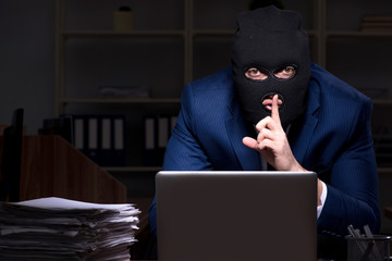 Male employee stealing information in the office night time