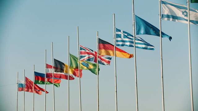 Flags of the world countries blowing in the wind on the background clear sky