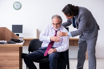 Male employee suffering from heart attack in the office