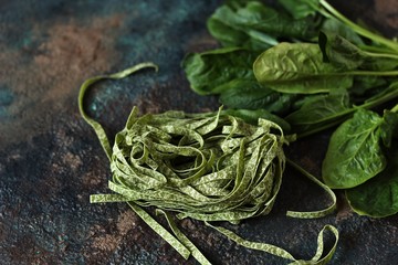 uncooked fettuccine pasta with spinach leaves. vegetarian cuisine.