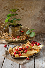 Traditional Ukrainian or Russian pancakes with strawberry berries and honey on wooden table. Shrovetide Maslenitsa Butter week festival meal. Slavic cuisine concept. Beautiful drop of honey