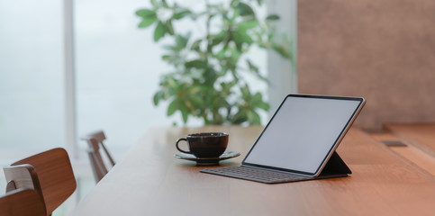 Blank screen tablet and a cup of coffee in comfortable workplace
