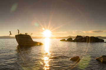 Fototapeta na wymiar People jumping off Bonsai Rock in Lake Tahoe, California