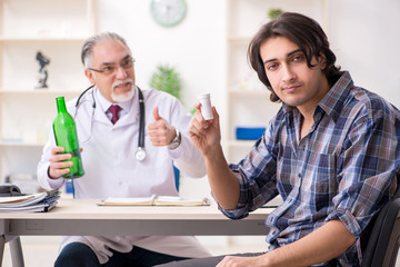 Young male alcoholic visiting old doctor