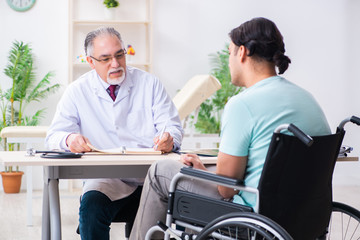 Male patient in wheel-chair visiting old doctor