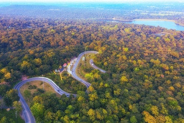 The aerial view of beautiful road grand curve with a steep and slithering track and autumn leaves in the spring season.