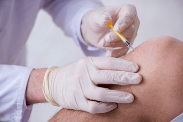 Male patient visitng doctor for shot inoculation