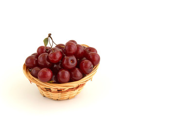 Fresh red cherries in wicker basket isolated on white background