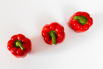 Three red bell peppers on the table, top view