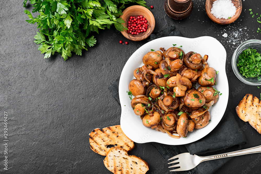 Wall mural fried mushrooms with fresh herbs in white plate. top view.