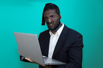 hacker with his head covered with a stocking, and with a threatening look, in front of his computer