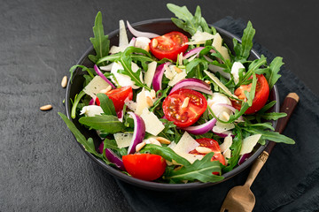 Fresh arugula salad with pine nuts, cherry tomatoes and parmesan cheese.