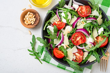 Fresh arugula salad with pine nuts, cherry tomatoes and parmesan cheese.