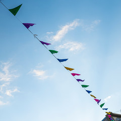 Colourful party flags on an outdoor scene under a blue sky