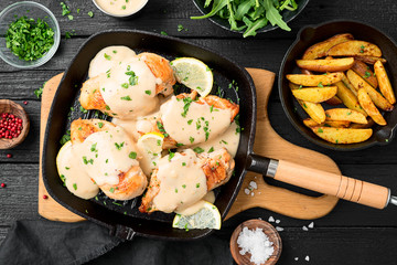 Fresh chicken breast seared in a cast iron skillet with creamy pan sauce.