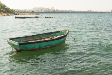 Naklejka na ściany i meble boat on the turquoise sea waves, near the shore