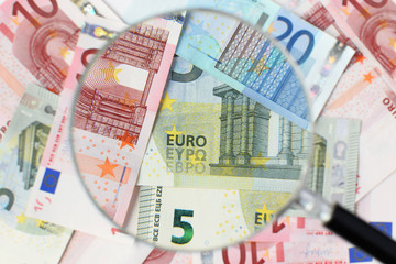 Euro banknotes under magnifying glass. Money background