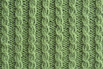 Light green knitted texture, background. Hand knitted cable pattern. Closeup