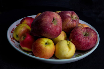 apples in a plate on a black background