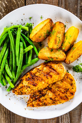 Grilled chicken fillets, baked potatoes and green beans